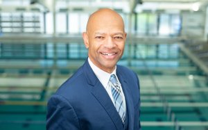 Joe Major in a blue suit facing the camera with a smile