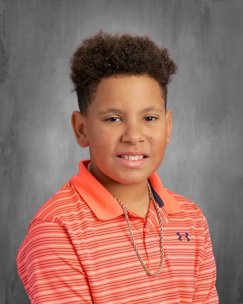 Elias Urang in a school photo, wearing an orange collared shirt and facing the camera